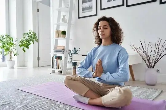 Woman meditating peacefully in a bright room