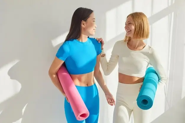 Two people smiling and talking in the yoga studio lounge