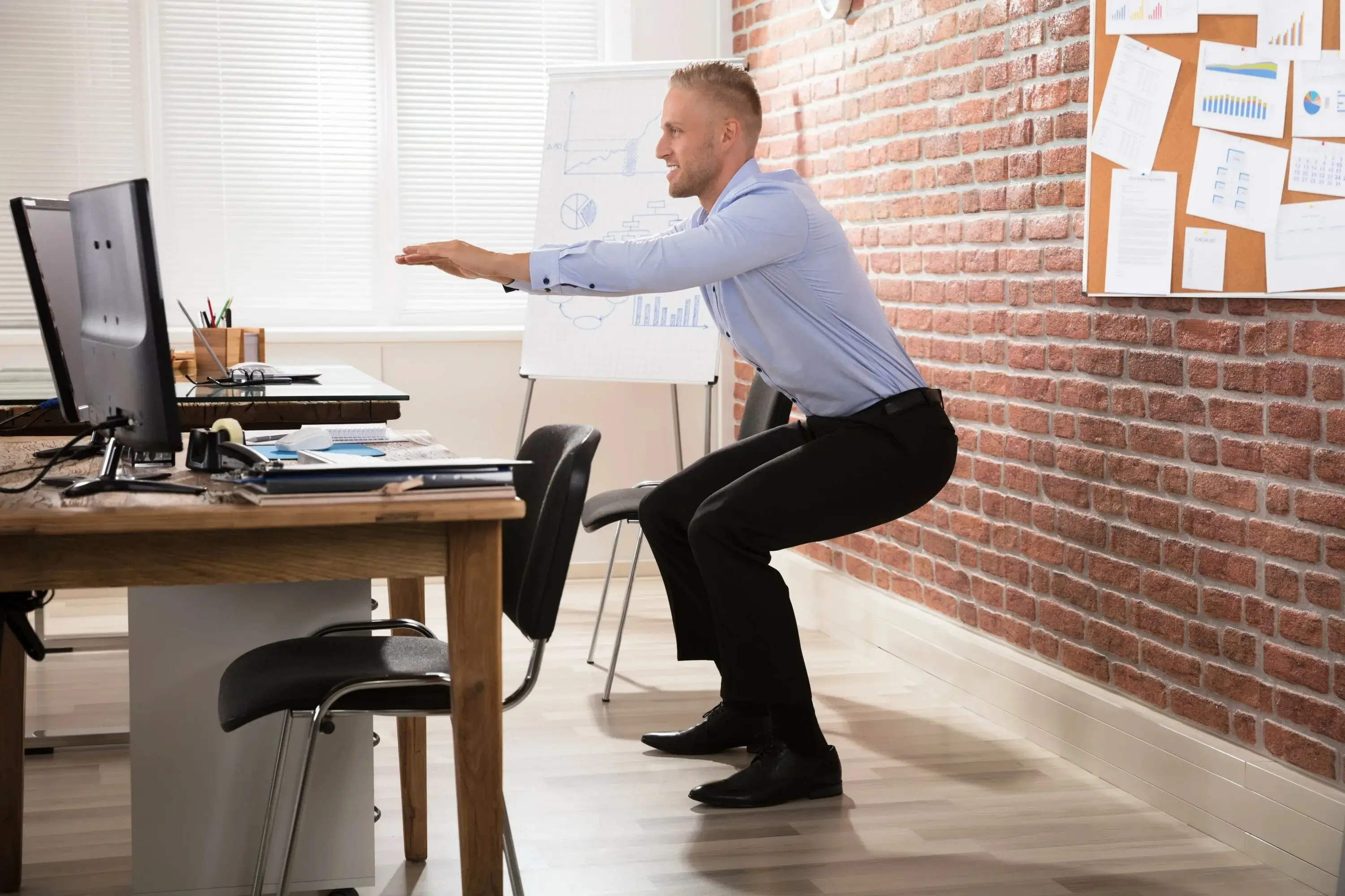 Person sitting at a desk and stretching